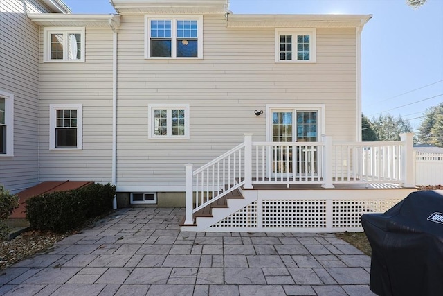 back of property featuring a deck and a patio area