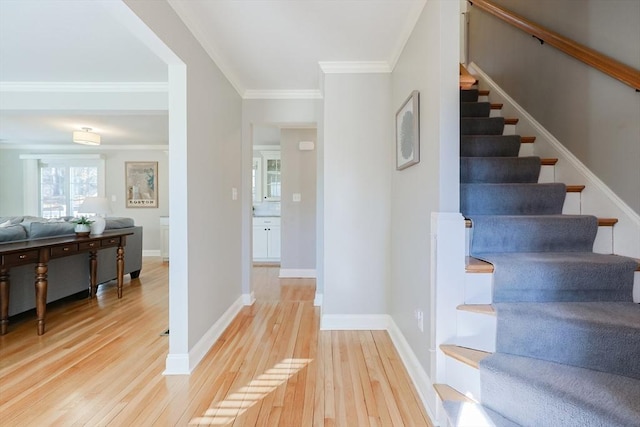 staircase with hardwood / wood-style floors and crown molding