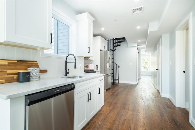 221 Paris St Unit 1, Boston, MA 02128 - kitchen featuring stainless steel appliances, decorative backsplash, white cabinetry, light countertops, and dark wood-style floors