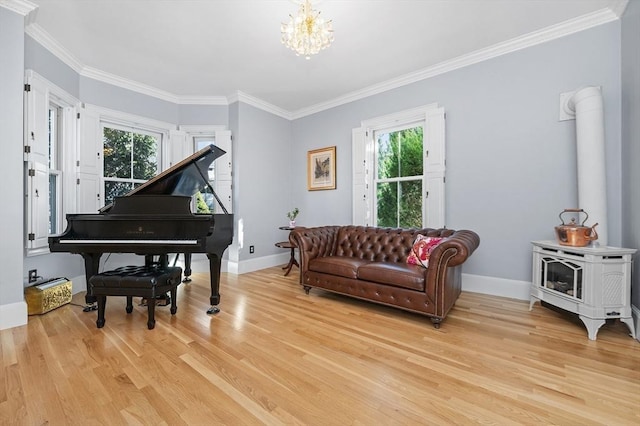 living room featuring a notable chandelier, crown molding, light wood-type flooring, and a wood stove