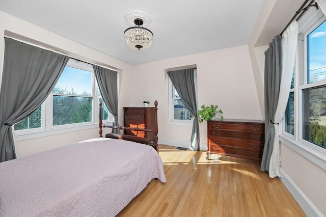 bedroom with light wood-type flooring and baseboards