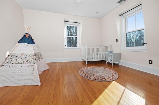 unfurnished bedroom featuring baseboards, multiple windows, and hardwood / wood-style flooring