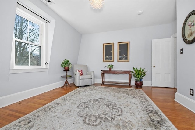 sitting room featuring visible vents, baseboards, and wood finished floors