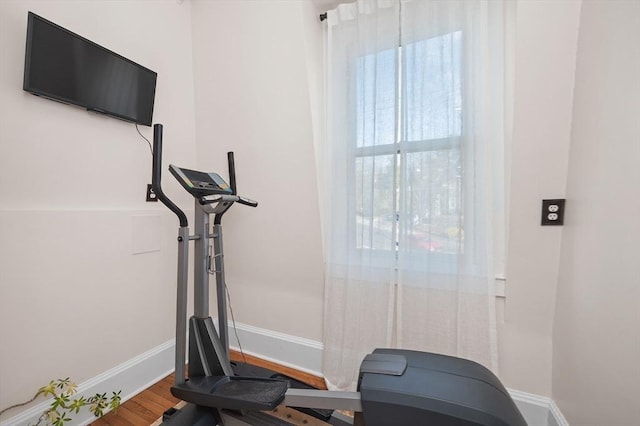 exercise room featuring baseboards and wood finished floors