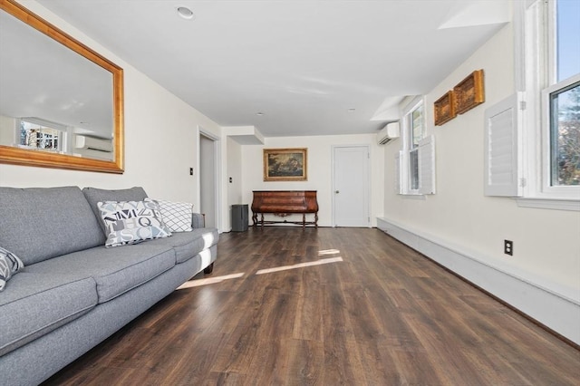 living room with a wealth of natural light, a wall unit AC, and wood finished floors