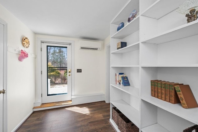 doorway to outside featuring dark wood finished floors and an AC wall unit