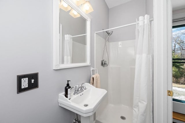 bathroom featuring a stall shower and a sink