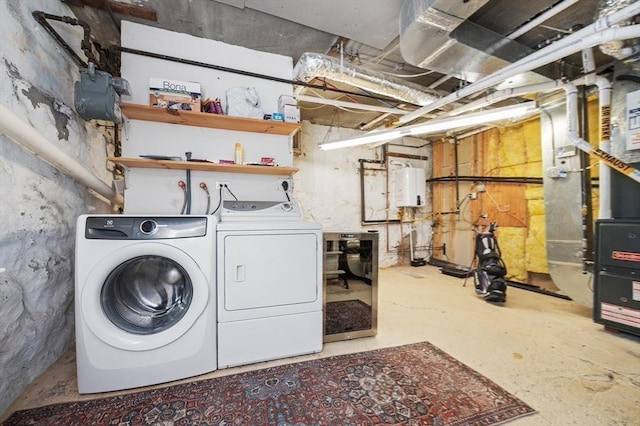 washroom featuring water heater, laundry area, and washing machine and dryer