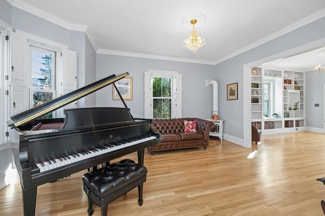 sitting room featuring baseboards, a notable chandelier, ornamental molding, and light wood finished floors