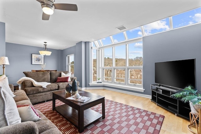 living room with light hardwood / wood-style flooring and ceiling fan