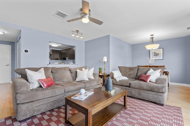 living room featuring ceiling fan and hardwood / wood-style floors