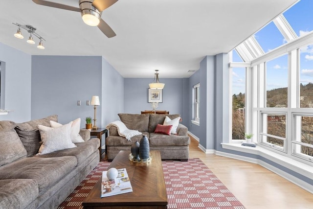 living room featuring ceiling fan, a healthy amount of sunlight, and light hardwood / wood-style floors