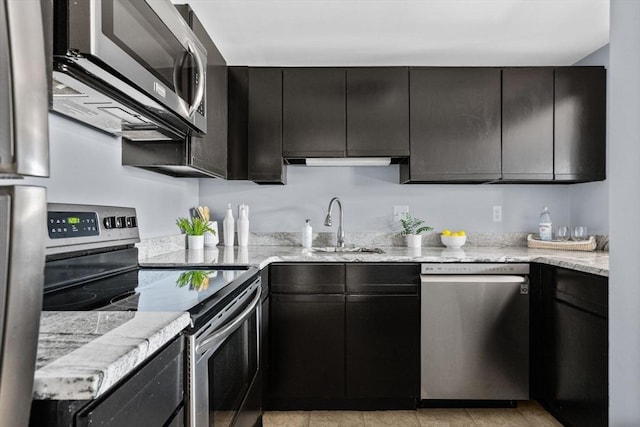 kitchen with sink, light stone counters, and appliances with stainless steel finishes