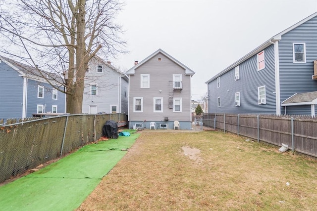 back of house featuring a residential view, a fenced backyard, and a yard