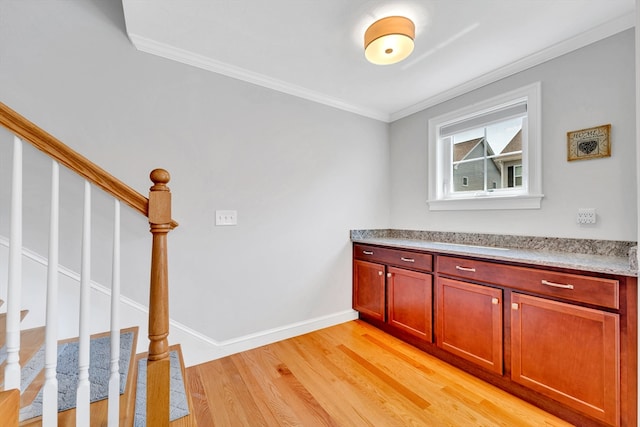 1400 Gorham Unit 3, Lowell, MA 01852 - kitchen with light wood finished floors, ornamental molding, and reddish brown cabinets
