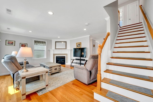 1400 Gorham Unit 3, Lowell, MA 01852 - living area with stairs, crown molding, light wood-style floors, a glass covered fireplace, and recessed lighting
