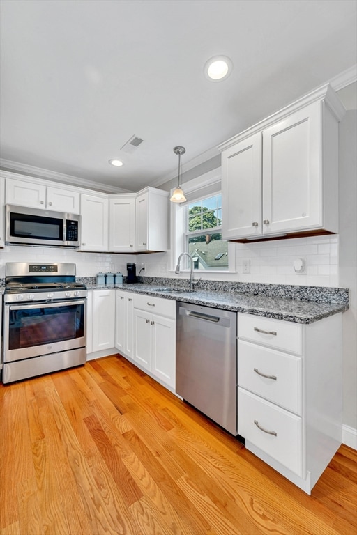 1400 Gorham Unit 3, Lowell, MA 01852 - kitchen with appliances with stainless steel finishes, white cabinets, recessed lighting, light wood-style floors, and ornamental molding