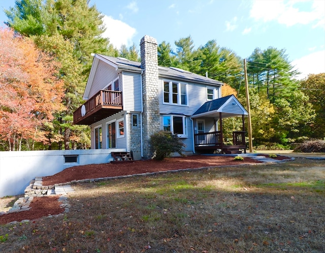 rear view of house with a balcony and a wooden deck