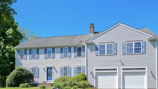 view of front facade with a chimney and an attached garage