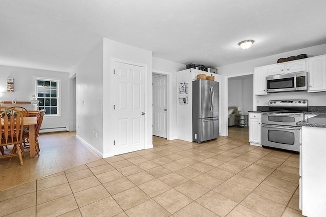kitchen with stainless steel appliances, a baseboard radiator, white cabinets, dark countertops, and light tile patterned floors