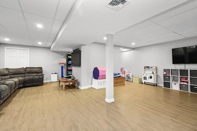 living room featuring a drop ceiling, wood finished floors, recessed lighting, and baseboards
