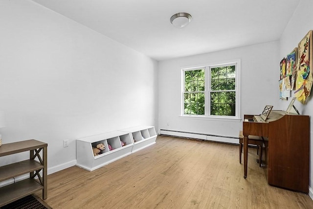 sitting room with a baseboard radiator, wood finished floors, and baseboards