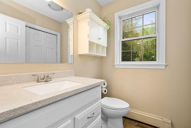 bathroom with a baseboard heating unit, vanity, toilet, and tile patterned flooring