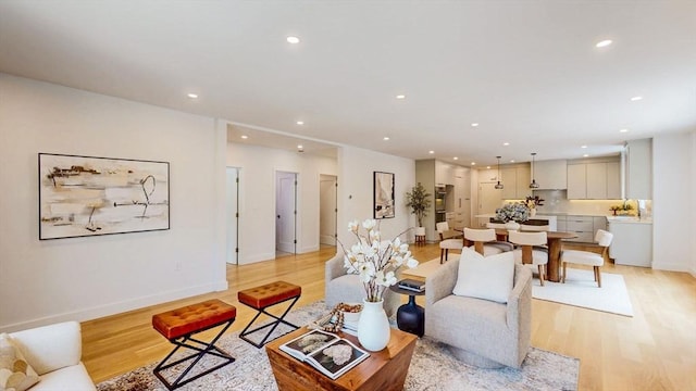 living room with light wood-style flooring, recessed lighting, and baseboards