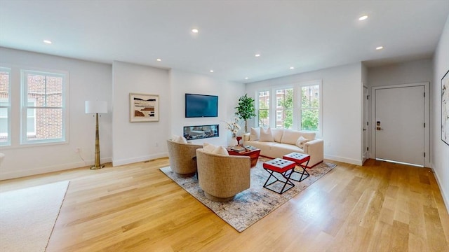 living room featuring light wood-type flooring, recessed lighting, and baseboards