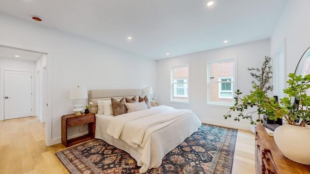 bedroom with light wood finished floors, recessed lighting, and baseboards