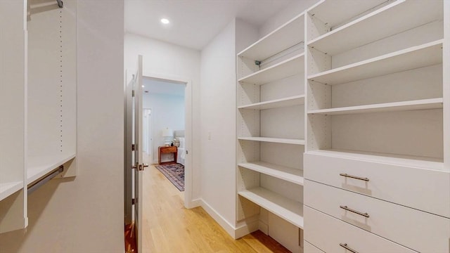 walk in closet with light wood-style flooring