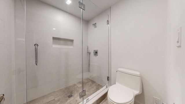 bathroom with toilet and a stall shower