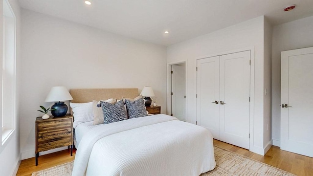bedroom featuring light wood-type flooring, a closet, recessed lighting, and baseboards