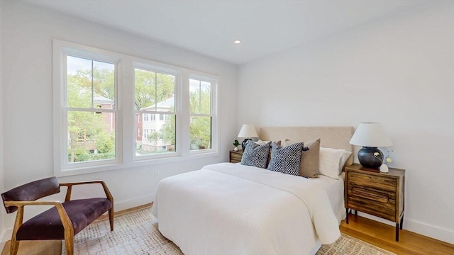 bedroom featuring baseboards, light wood finished floors, and recessed lighting