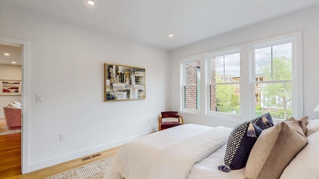 bedroom featuring wood finished floors, multiple windows, recessed lighting, and baseboards
