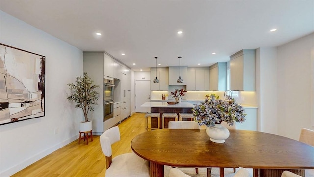 dining area with light wood-style floors, recessed lighting, and baseboards