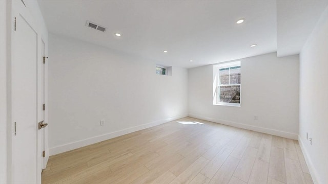 spare room featuring light wood finished floors, baseboards, and recessed lighting