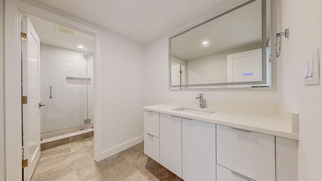 bathroom with a shower stall, vanity, baseboards, recessed lighting, and tile patterned flooring