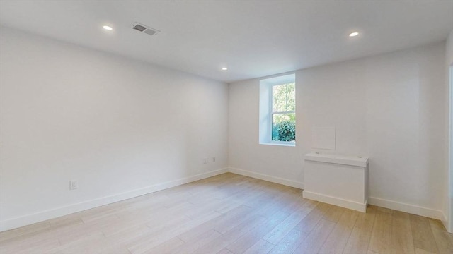 unfurnished room with light wood-type flooring, baseboards, and recessed lighting