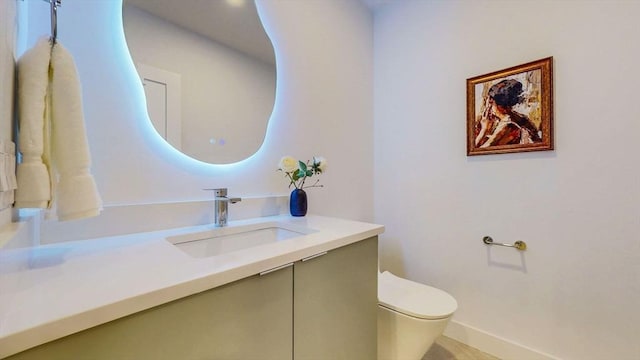 half bathroom featuring vanity and toilet