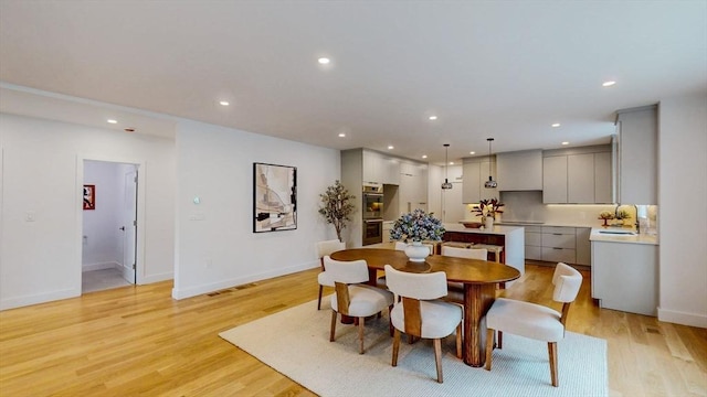 dining area featuring recessed lighting, baseboards, and light wood-type flooring