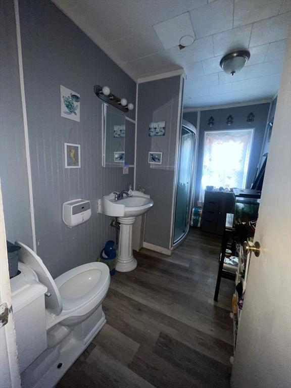 bathroom featuring toilet, wood-type flooring, and walk in shower