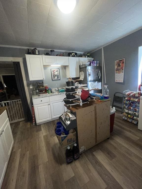 kitchen featuring fridge, dark wood-type flooring, white cabinetry, and ornamental molding