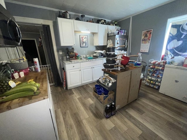 kitchen featuring sink, white cabinetry, and hardwood / wood-style floors