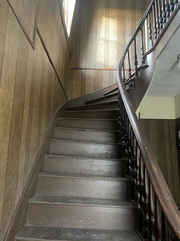 stairs featuring wood walls