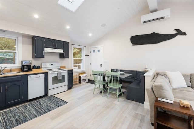 69 Naugus Ave, Marblehead, MA 01945 - kitchen featuring white appliances, a wall unit AC, a sink, under cabinet range hood, and light wood finished floors