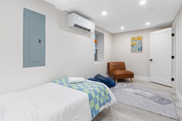 69 Naugus Ave, Marblehead, MA 01945 - bedroom with a wall unit AC, electric panel, light wood-style floors, recessed lighting, and baseboards