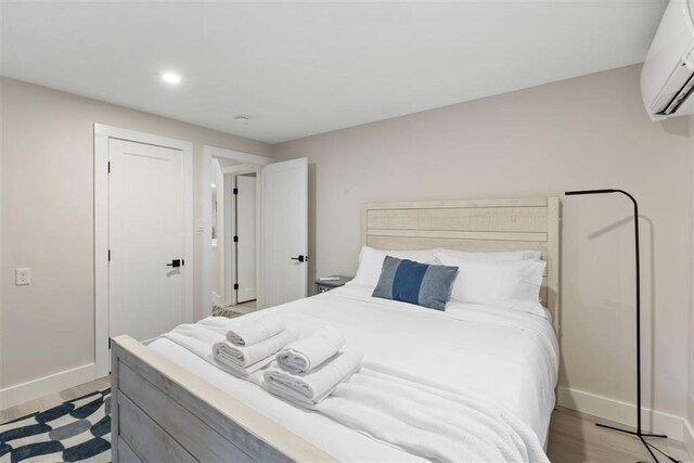 69 Naugus Ave, Marblehead, MA 01945 - bedroom featuring an AC wall unit, baseboards, recessed lighting, light wood-style flooring, and a closet
