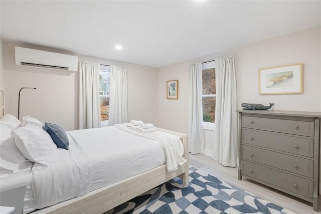 69 Naugus Ave, Marblehead, MA 01945 - bedroom featuring an AC wall unit, light wood finished floors, and recessed lighting