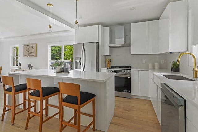 96 Dutton St, Malden, MA 02148 - kitchen with stainless steel appliances, wall chimney exhaust hood, decorative backsplash, light wood-style flooring, and white cabinetry